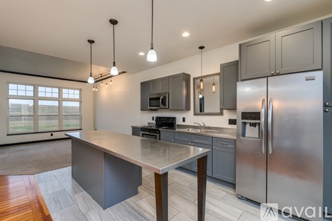 A modern kitchen with stainless steel appliances and a central island.