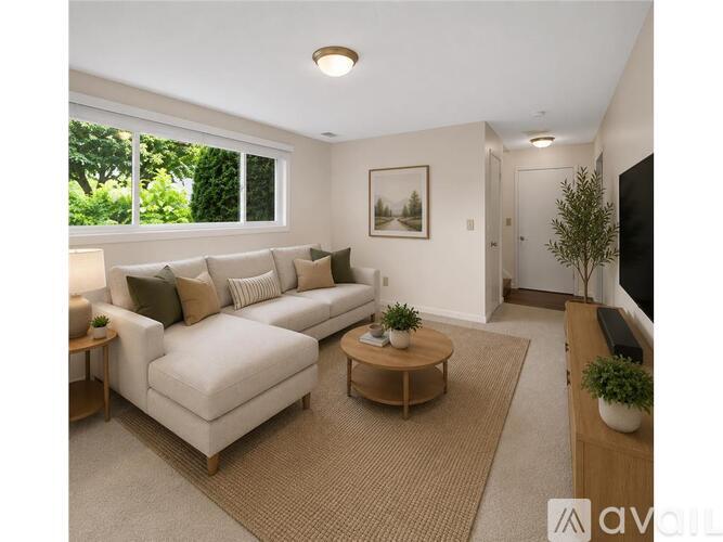 A living room with a white couch, a coffee table, and a painting on the wall.