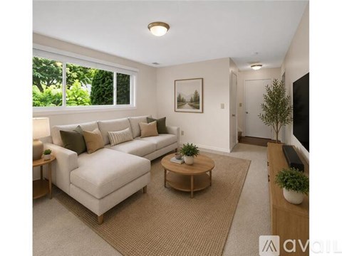 A living room with a white couch, a coffee table, and a painting on the wall.