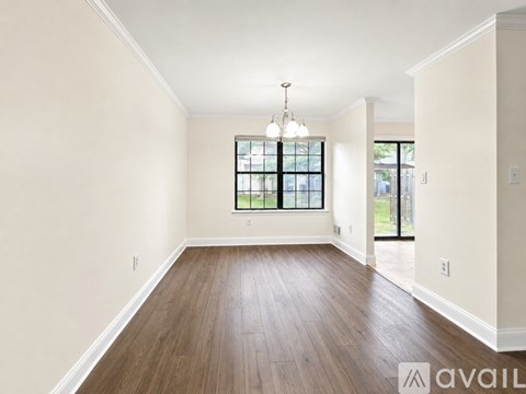 A spacious room with wooden floors and a large window.