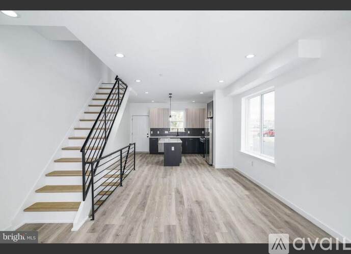 A spacious living room with a staircase leading to the upper floor.