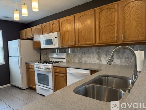 A kitchen with wooden cabinets and a stainless steel sink.
