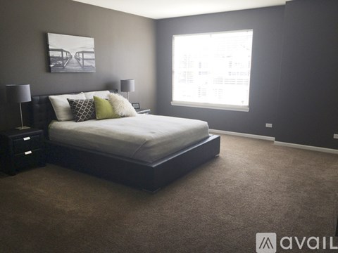 A bedroom with a large bed and two lamps.