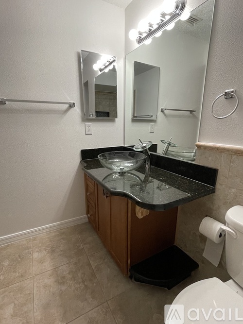 A bathroom with a sink, mirror, and toilet.