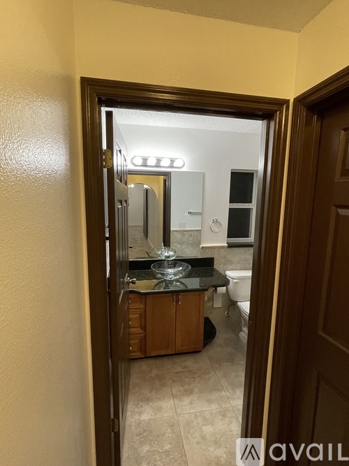 A bathroom with a mirror and sink is visible through an open door.