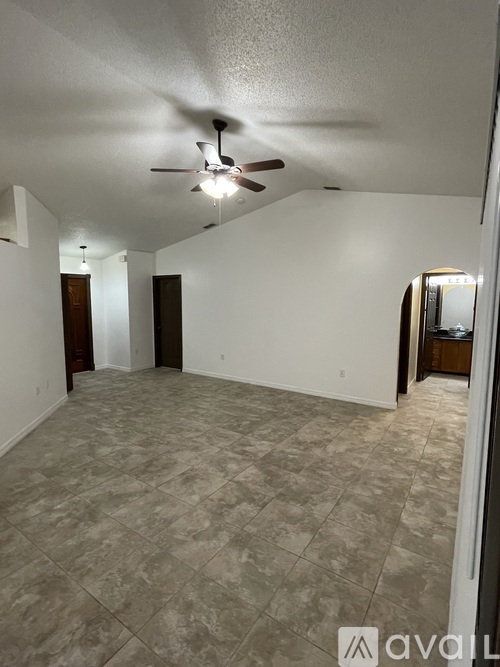 A room with a ceiling fan and tile flooring.