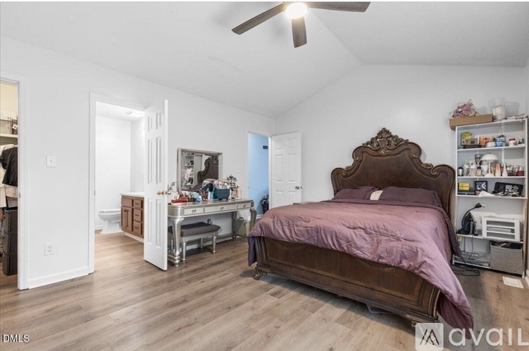 A bedroom with a large bed and a desk with a chair.