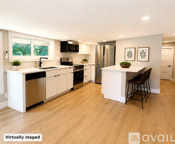 A kitchen with white cabinets and a wooden floor.