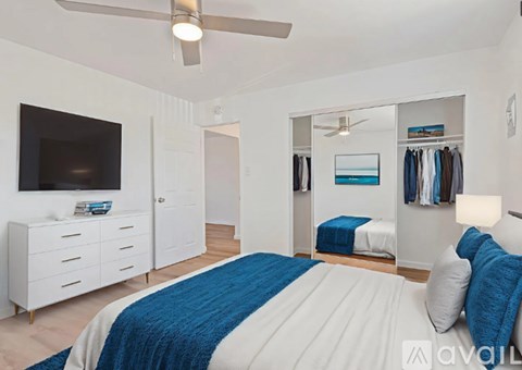 A bedroom with a bed, a dresser, a mirror, and a ceiling fan.