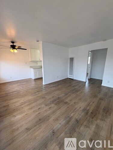 A room with wooden flooring and a ceiling fan.