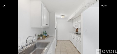 A kitchen with white cabinets and a marble countertop.