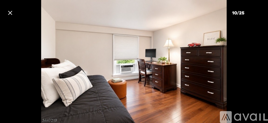 A bedroom with a large bed and a wooden dresser.