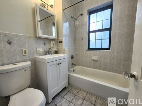 A bathroom with a tub, toilet, and sink.