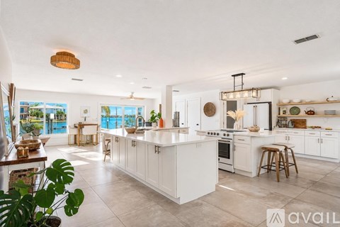 A modern kitchen with white cabinets and a large island.