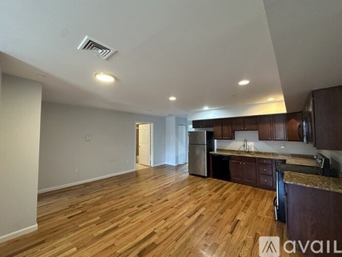A kitchen with wooden floors and a refrigerator.