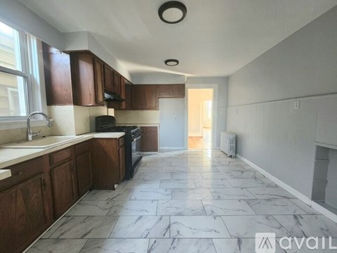 A kitchen with brown cabinets and a black stove top oven.