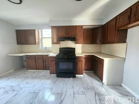 A kitchen with a black oven and brown cabinets.
