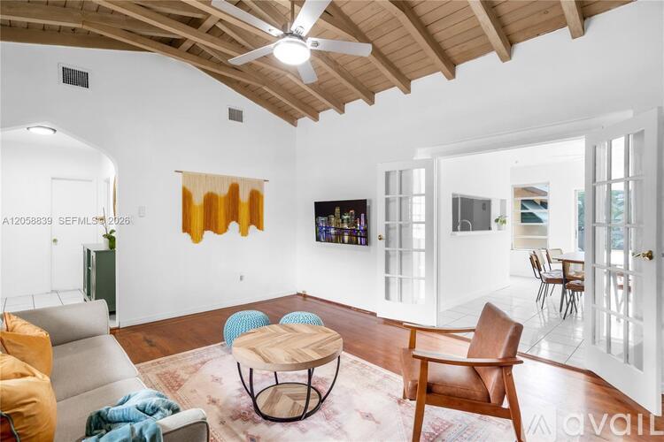 A living room with a wooden ceiling and a brown sofa.