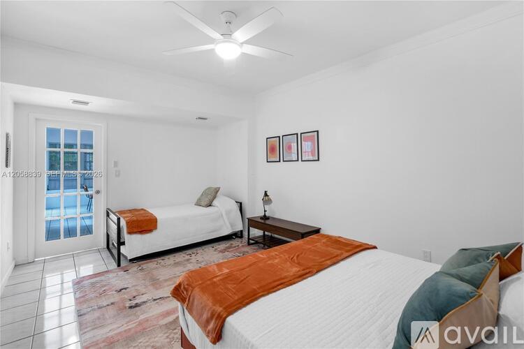 A bedroom with two beds and a ceiling fan.