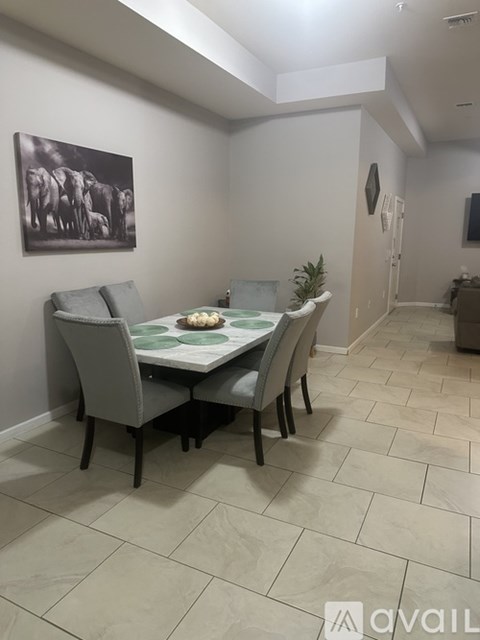 A dining room with a table and chairs.