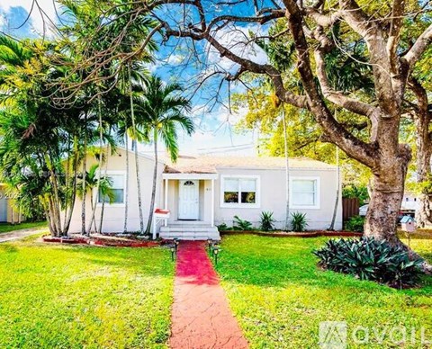 A white house with a red pathway leading to the front door.