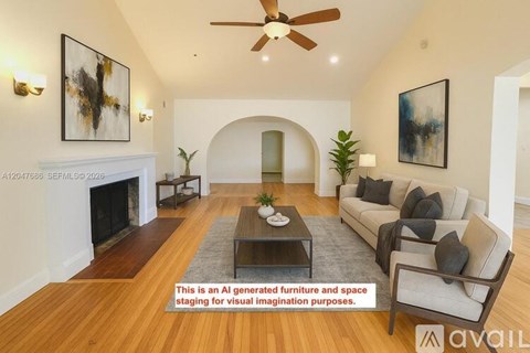 A living room with a fireplace, a couch, a coffee table, and a painting on the wall.