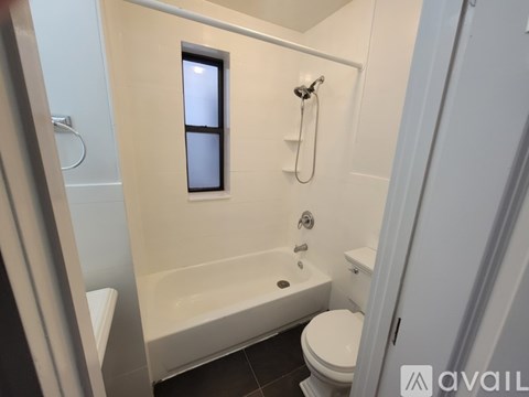 A bathroom with a white tub, toilet, and sink.