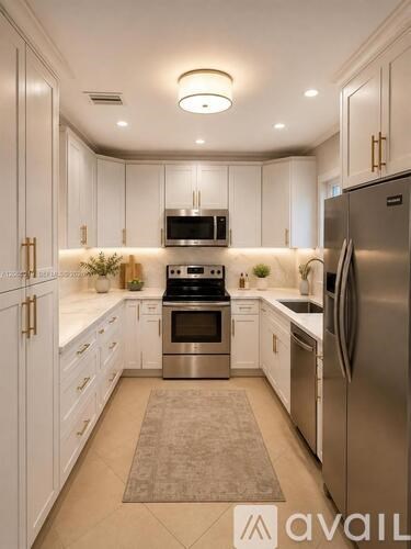 A modern kitchen with white cabinets and stainless steel appliances.