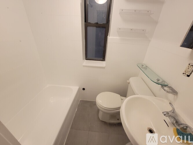A white toilet sits next to a sink in a small bathroom.