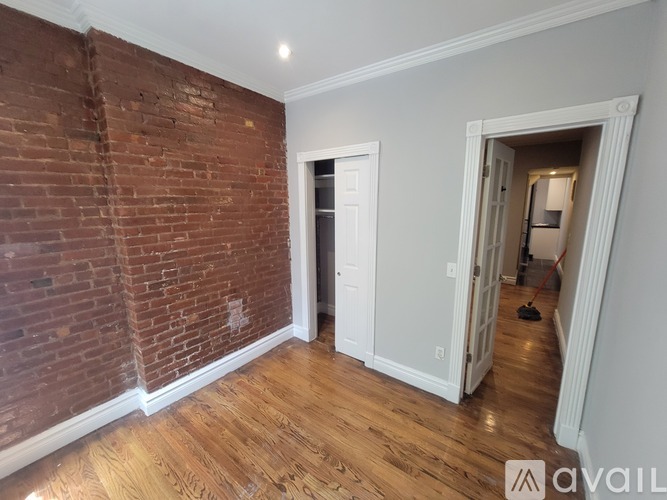 A room with a brick wall and wooden flooring.