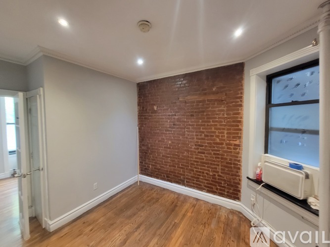 A room with a brick wall and wooden flooring.