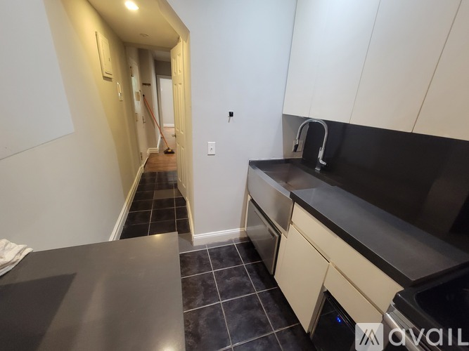 A kitchen with black countertops and white cabinets.