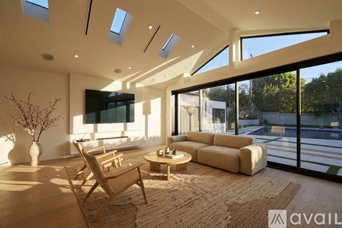 A modern living room with a large window and a flat screen TV.