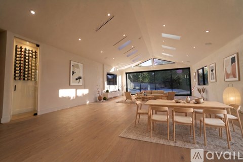 A modern dining room with a wooden table and chairs.