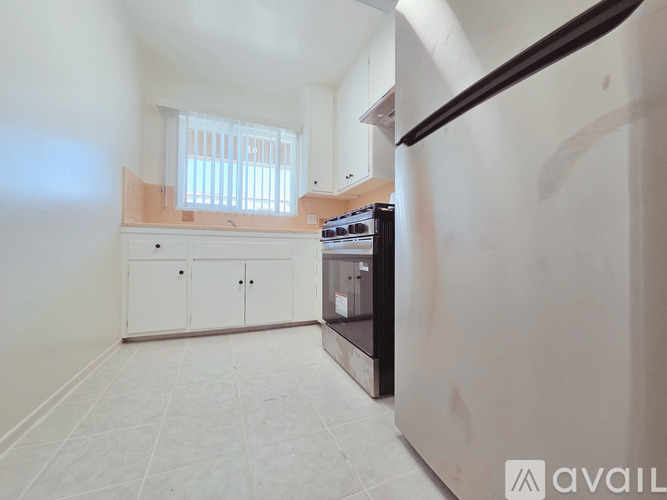 A kitchen with white cabinets and a black oven.