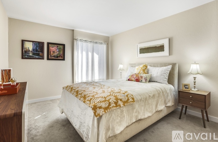 A bedroom with a large bed and a lamp on a side table.