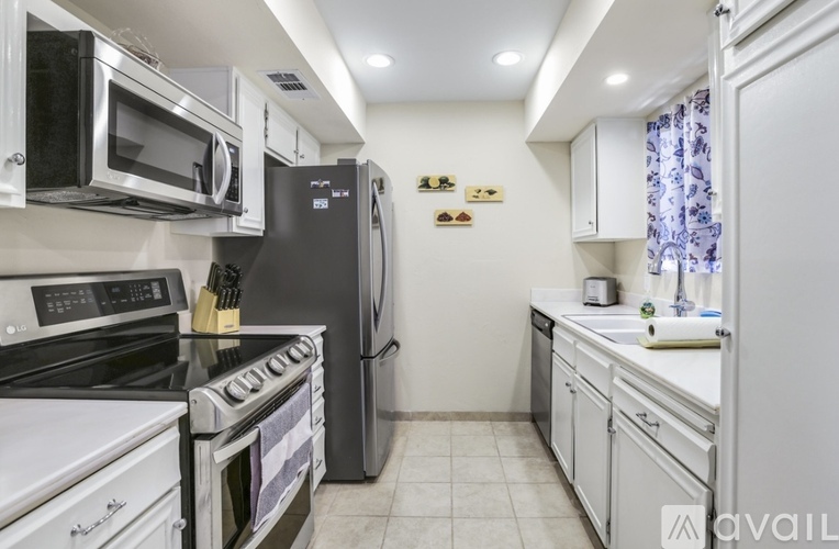 A kitchen with white appliances and a black stove top.