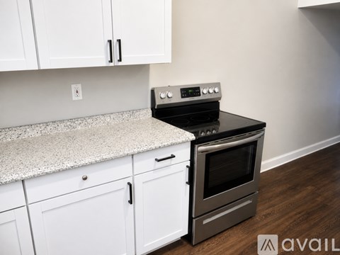 A kitchen with white cabinets and a granite countertop.