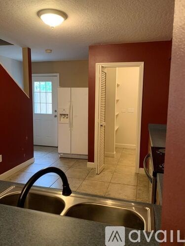 A kitchen with a sink and a refrigerator.