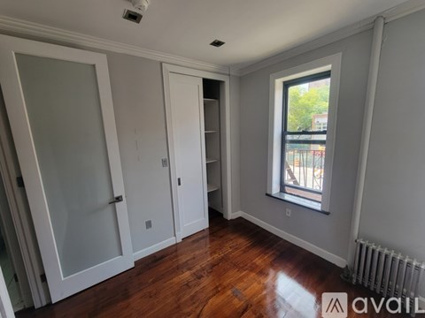 A room with a window and a radiator on the floor.