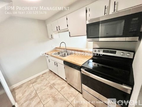 A kitchen with a stove top oven and microwave above it.