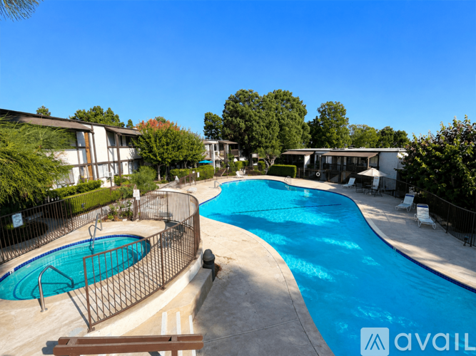 A swimming pool surrounded by a fence and trees.