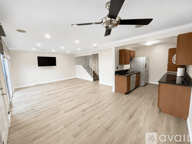 A spacious living room with a television and a fan.