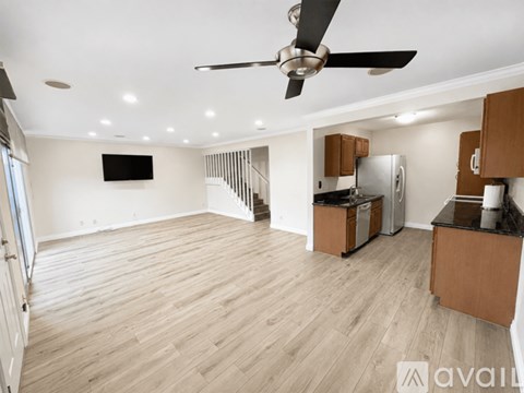A spacious living room with a television and a fan.