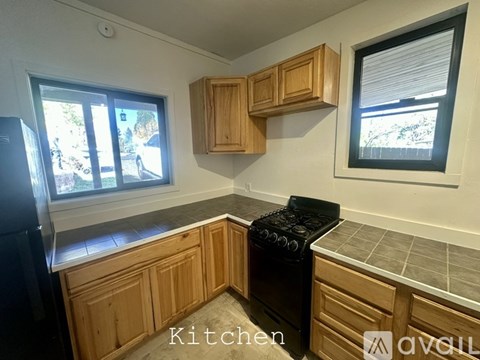 A kitchen with wooden cabinets and a black stove top oven.