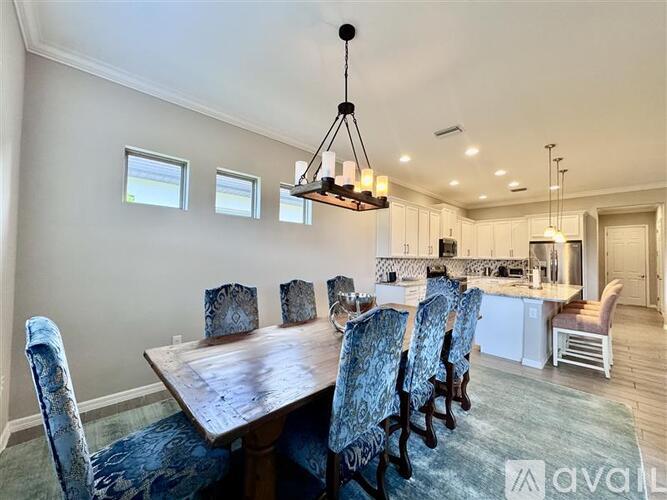 A dining room with a wooden table and chairs.