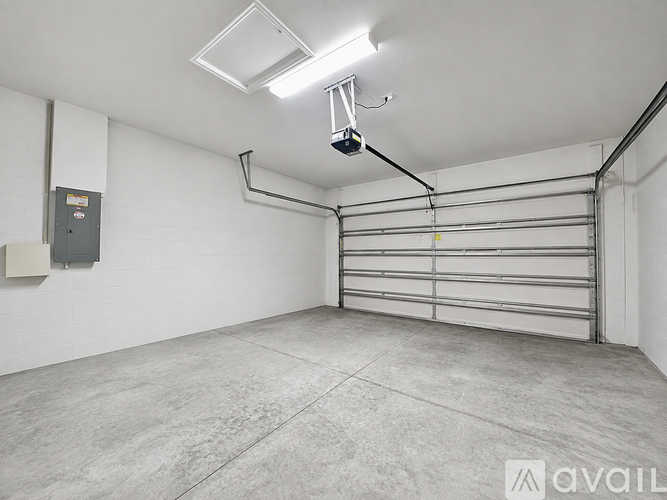 A spacious garage with a metal rolling shelf and a fluorescent light fixture.