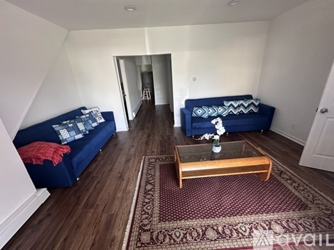 A living room with a blue couch and a wooden coffee table.