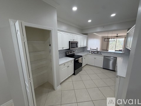 A kitchen with white cabinets and appliances, a refrigerator, a microwave, a stove, a dishwasher, and a sink.