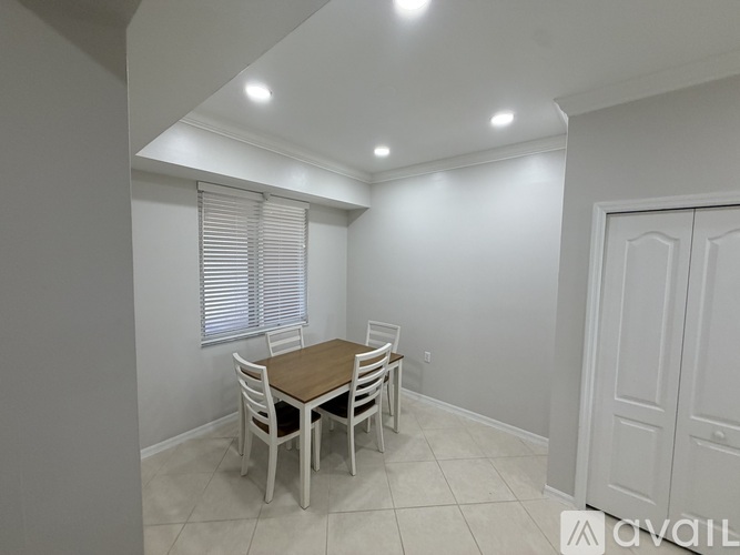 A dining room with a table and chairs.